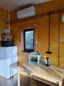 Il comprend une petite cuisine équipée d'une table et d'un réfrigérateur. dans l'établissement Янтарь Уютный горный домик, à Almaty