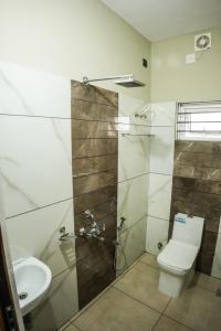 Zennova Furnished Apartment في أليبي: حمام مع مرحاض ومغسلة