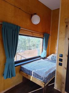 a bedroom with a window and a bed in a room at Янтарь Уютный горный домик in Almaty