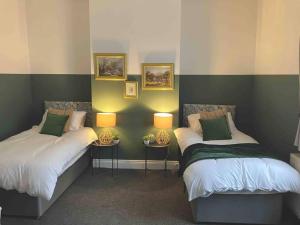 two beds in a room with two lamps on them at Rose Cottage - 5 Person city centre with parking in Sunderland
