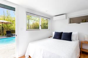 a bedroom with a bed and a swimming pool at The Pines Men-Only Stay in Fire Island Pines
