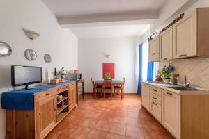 cocina con fregadero, TV y mesa en L'Angolo di Ponte Vecchio, en Florencia