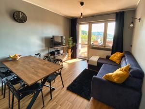 uma sala de estar com um sofá azul e uma mesa em Apartament Loft Krynica-Zdrój em Krynica-Zdrój