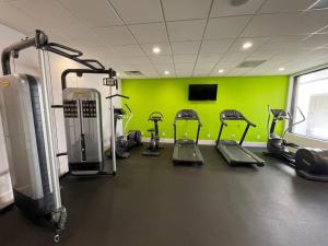 een fitnessruimte met verschillende loopbanden en een groene muur bij Newly renovated room in cozy hotel near Disney in Kissimmee