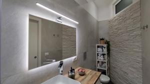 uma casa de banho com um lavatório e um espelho em Bella 'Mbriana Home em Nápoles