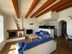 een woonkamer met 2 banken en een open haard bij ES CASTELL 2 5 by SOM Menorca in Fornells