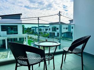 balcón con mesa y sillas y vistas a la calle en Haven Homestay晶晶屋 (Brand New Homestay!), en Kampong Sungai Udang
