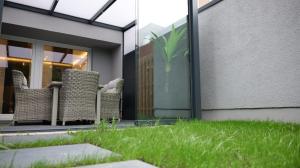 eine Terrasse mit Gras- und Korbstühlen vor einem Gebäude in der Unterkunft Spa Lounge Hannover in Hannover