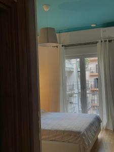 1 dormitorio con cama y ventana grande en Dream Central Appartment, en Tesalónica