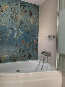 a bathroom with a bath tub with a floral wallpaper at Dream Central Appartment in Thessaloniki