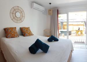 a bedroom with a bed with blue pillows on it at L'Entre-Nous Carcassonne in Carcassonne