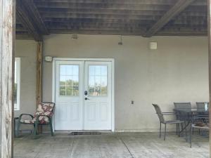 a porch with a white door and chairs and a table at Lakeside serenity in Newnan in Newnan +3 photos