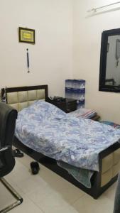 a bedroom with a bed with a blue comforter at An appartment for rent in Ajman Alreqah Building in Ajman 