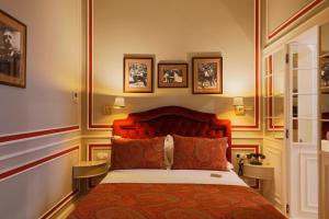- une chambre avec un lit et des photos sur le mur dans l'établissement Grande Hotel do Porto, à Porto 37 autres photos