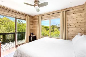 a bedroom with a bed and large windows at Fire Island Pines Rooms in Fire Island Pines