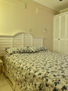 a bedroom with a bed with a floral comforter at Kenridge Residences in Saint James