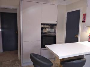 a kitchen with a white table and a black oven at Number Fifty-Six Ramsey Villa in Ramsey