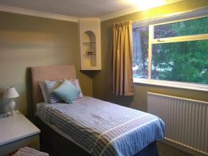 ein kleines Schlafzimmer mit einem Bett und einem Fenster in der Unterkunft Number Fifty-Six Ramsey Villa in Ramsey