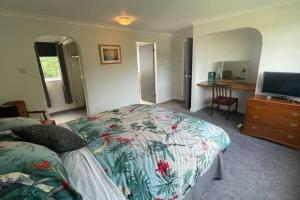 a bedroom with a bed and a dresser with a television at Number Fifty-Six Ramsey Villa in Ramsey