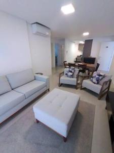 a living room with a white couch and a table at Summer Paradise - 3 Quartos in Governador Celso Ramos