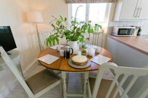 a small table with a cake on it in a kitchen at Hideaway in Rhosneigr