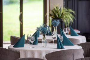 a group of tables with blue napkins and flowers on them at Amicus Hotel in Vilnius
