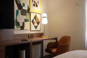 Habitación con escritorio con lámpara y silla. en Holiday Inn Durango, an IHG Hotel, en Durango