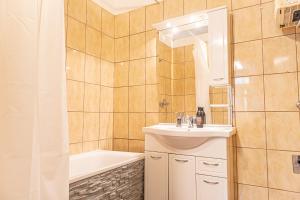 y baño con lavabo, bañera y aseo. en Elegant Haven: Stylish and Spacious 3BR Apartment, en Viena