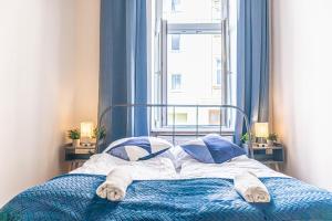 1 cama con manta y almohadas azules y ventana en Elegant Haven: Stylish and Spacious 3BR Apartment, en Viena