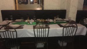 a table with a white table cloth and two chairs at HOTEL Quito Antiguo in Quito