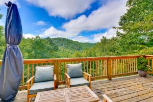 una terraza con 2 sillas y una sombrilla en Mtn View and Fire Pit Pet-Friendly Woodlawn Cabin!, en Woodlawn