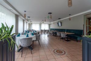 ein Restaurant mit Tischen und Stühlen in einem Zimmer in der Unterkunft Amicus Hotel in Vilnius
