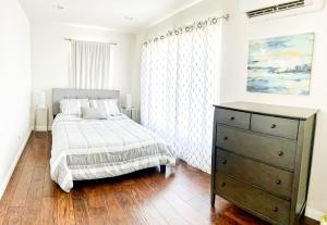 a bedroom with a bed and a dresser in it at Modern 2-Bedroom Haven in the Heart of LA- HUD-VP in Los Angeles