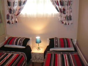 2 camas individuais num quarto com uma janela em 202 Bermuda em Ballito