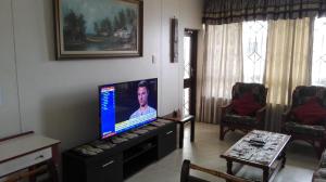 uma sala de estar com uma televisão de ecrã plano sobre uma mesa em 202 Bermuda em Ballito