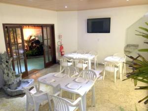 een eetkamer met witte tafels en witte stoelen bij Pousada Belafonte Riocentro in Rio de Janeiro