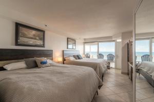 a hotel room with two beds and a balcony at DBR Direct Oceanfront Condo, Daytona Beach, sleeps 6 in Daytona Beach