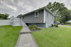 a gray house with a lawn in front of it at Cozy Massachusetts Retreat 30 min to Boston! in Bedford