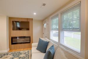 uma sala de estar com um sofá e uma televisão em Beautiful 3 BR Home with Workspace 20 Min to Boston em Bedford