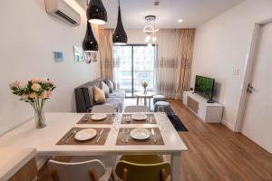 a kitchen and living room with a table and chairs at Republic Apartments Saigon Airport in Ho Chi Minh City