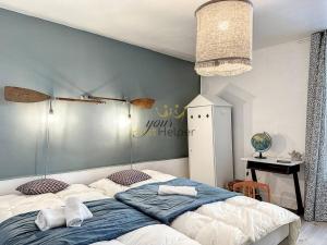 een slaapkamer met een groot bed en een tafel bij La Marine YourHostHelper in Trouville-sur-Mer