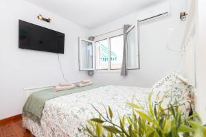 a bedroom with a bed and a flat screen tv at Hilltop Vista Apartment in Puerto Rico de Gran Canaria