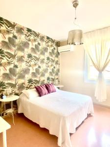 1 dormitorio con 1 cama con pared de flores en Bed&Breakfast A Bologna en Bolonia