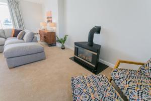 a living room with a fireplace and a couch at Garreg Hen in Trearddur