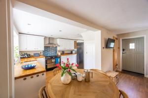 a kitchen and dining room with a wooden table at Victoria Cottage in Northrepps