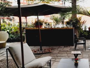 a patio with an umbrella and a couch and a table at La Varangue in Antananarivo