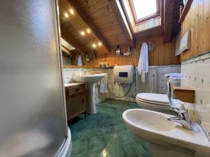 a bathroom with two sinks and a toilet and a window at Trilocale Il Cardo, Giustino in Giustino +20 photos