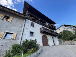 a building with a balcony on the side of it at Trilocale Il Cardo, Giustino in Giustino