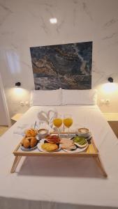 a tray of food on a bed with two glasses of wine at Hostal Avenida Andalucia in Seville
