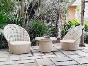 twee stoelen en een tafel op een patio met planten bij La Varangue in Antananarivo